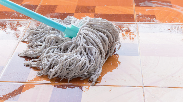 a mop on a wet tile floor