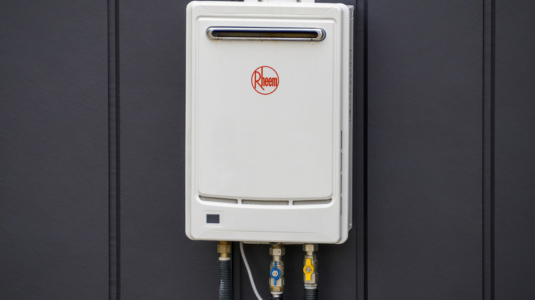 A tankless gas water heater installed on a basement wall